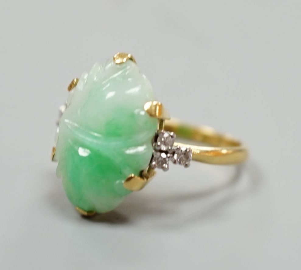 An 18ct, carved jade cabochon and diamond set oval dress ring, size O, gross weight 6.2 grams.